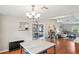Bright dining area featuring hardwood floors, modern chandelier, and open layout to the living spaces at 1038 Shenandoah Ln, Spring Hill, FL 34606