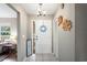 Entryway with white tile flooring, white front door and decorative artwork at 1038 Shenandoah Ln, Spring Hill, FL 34606