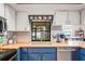 Traditional kitchen sink and countertop space with painted white cabinets and blue under-cabinetry at 1038 Shenandoah Ln, Spring Hill, FL 34606