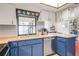 Traditional kitchen sink and countertop space with painted white cabinets and blue under-cabinetry at 1038 Shenandoah Ln, Spring Hill, FL 34606