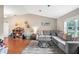 Spacious living room with wood floors, vaulted ceiling, and comfortable gray sectional at 1038 Shenandoah Ln, Spring Hill, FL 34606
