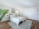 Comfortable bedroom featuring bright interior, neutral decor, rug, painting and wood look floors at 105 4Th Ne Ave # 426, St Petersburg, FL 33701