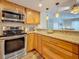 Kitchen featuring wood cabinets, granite counters, stainless appliances, and an open view to the living area at 105 4Th Ne Ave # 426, St Petersburg, FL 33701