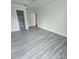 Spacious bedroom with wood-look flooring and an attached bath at 1107 Queen Anne Dr # C, Palm Harbor, FL 34684
