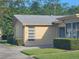 This property features light yellow paint, well-maintained lawns, and neat shrubbery at 1107 Queen Anne Dr # C, Palm Harbor, FL 34684