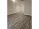 Spacious living room boasts new gray wood-look flooring, white walls, and plenty of room at 1107 Queen Anne Dr # C, Palm Harbor, FL 34684