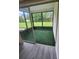 Screened porch with artificial grass and sliding doors to the backyard at 1107 Queen Anne Dr # C, Palm Harbor, FL 34684