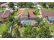 Aerial shot showcases the screened-in pool and patio area in the backyard, bordered by a white fence and green foliage at 111 Falling Water Dr, Brandon, FL 33511