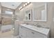 Elegant bathroom featuring a double vanity, decorative mirrors, and a shower/tub combo with glass doors at 111 Falling Water Dr, Brandon, FL 33511