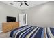 Bright bedroom featuring a ceiling fan, a striped bed, and a dresser with a television at 111 Falling Water Dr, Brandon, FL 33511