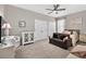 Spacious bedroom with a ceiling fan, plush carpet, and a seating area with a gray sofa at 111 Falling Water Dr, Brandon, FL 33511
