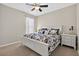 Bright bedroom with a ceiling fan, plush carpet, and a large white bed with patterned bedding at 111 Falling Water Dr, Brandon, FL 33511