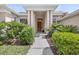 Inviting front entrance with decorative landscaping, a charming pathway, and a solid wood door at 111 Falling Water Dr, Brandon, FL 33511