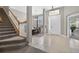 Entryway boasting natural light, tile flooring, a staircase with wooden banister, and a view into the office at 111 Falling Water Dr, Brandon, FL 33511