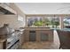 Well-equipped outdoor kitchen with a built-in grill, refrigerator, and bar seating overlooking the pool at 111 Falling Water Dr, Brandon, FL 33511