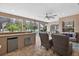 This screened outdoor kitchen features a granite bar, mini fridge, and comfortable seating for poolside enjoyment at 111 Falling Water Dr, Brandon, FL 33511