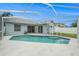 Backyard view of a private pool and a covered patio with sliding glass doors providing access to the home at 11222 Clayridge Dr, Tampa, FL 33635
