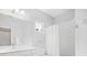 Neutral-toned bathroom showcasing a large mirror, all white cabinets, and a combination shower and bath at 11429 Drifting Leaf Dr, Riverview, FL 33579