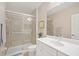 Well-lit bathroom with a single vanity, large mirror, and glass-enclosed shower at 11429 Drifting Leaf Dr, Riverview, FL 33579