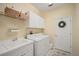Well-equipped laundry room with white cabinets, washer, dryer, sink, and ample storage space at 11429 Drifting Leaf Dr, Riverview, FL 33579