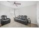 Comfortable living room featuring a ceiling fan, plush carpet, and a black leather sofa set for relaxation at 11429 Drifting Leaf Dr, Riverview, FL 33579