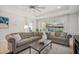 Comfortable living room with neutral tones, a ceiling fan, and sliding glass doors to the pool area at 11429 Drifting Leaf Dr, Riverview, FL 33579