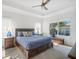 Bright main bedroom with tray ceiling, ceiling fan, and large windows overlooking lanai at 11429 Drifting Leaf Dr, Riverview, FL 33579