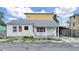 Charming single-story home with a covered front porch and American flags, ready for loving care at 131 92Nd Ave, Treasure Island, FL 33706