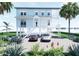 Charming waterfront house on stilts featuring two cars parked in the driveway and tropical landscaping at 131 92Nd Ave, Treasure Island, FL 33706
