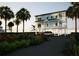 Charming waterfront house on stilts featuring two cars parked in the driveway and tropical landscaping at 131 92Nd Ave, Treasure Island, FL 33706