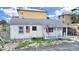 Charming street view of a single-story house featuring a quaint front porch, American flag and a covered carport at 131 92Nd Ave, Treasure Island, FL 33706