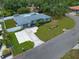 An aerial view showcases the property's beautiful landscaping, mature trees and long driveway at 13514 Oval W Dr, Largo, FL 33774