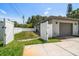 Backyard featuring well-maintained lawn, white fencing, and access to a garage, creating a neat and private outdoor space at 13514 Oval W Dr, Largo, FL 33774