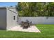 Backyard featuring paver patio with outdoor dining area, well-maintained lawn, and privacy fence at 13514 Oval W Dr, Largo, FL 33774
