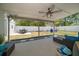 Backyard featuring covered patio, dining set, white fencing, and manicured lawn at 13514 Oval W Dr, Largo, FL 33774