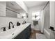 Bathroom featuring dual sinks, matte black hardware, wood-look flooring, and a shower-tub combo at 13514 Oval W Dr, Largo, FL 33774