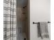 Bathroom shower featuring a tan tiled shower with a seating area, a rainfall shower head, and a striped shower curtain at 13514 Oval W Dr, Largo, FL 33774