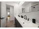 Bathroom featuring dual sinks with matte black hardware, wood-look flooring, and a shower at 13514 Oval W Dr, Largo, FL 33774