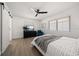 Cozy bedroom featuring a ceiling fan, natural light, barn door, and a gray throw blanket over the bed at 13514 Oval W Dr, Largo, FL 33774