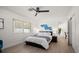 Bright bedroom with a ceiling fan, natural light from the window, and a blue shark art piece above the bed at 13514 Oval W Dr, Largo, FL 33774