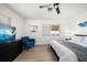 Comfortable bedroom featuring natural light, a modern ceiling fan, blue chair, and mounted TV at 13514 Oval W Dr, Largo, FL 33774