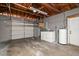 A garage space featuring a large garage door, open wooden rafters, with a washer and dryer ready for use at 13514 Oval W Dr, Largo, FL 33774