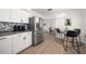 Contemporary kitchen with stainless steel refrigerator, stylish backsplash, and breakfast nook seating at 13514 Oval W Dr, Largo, FL 33774