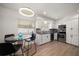 Bright kitchen featuring white cabinetry, stainless appliances, hexagonal backsplash, and a modern, round light fixture at 13514 Oval W Dr, Largo, FL 33774