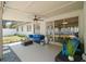Covered outdoor patio with ceiling fan, sliding glass doors, and a comfortable seating area with a blue sofa and coffee table at 13514 Oval W Dr, Largo, FL 33774