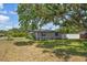 A quiet side yard with mature tree coverage and privacy fence at 13514 Oval W Dr, Largo, FL 33774