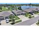 An aerial view of a home with a three-car garage, situated beside a lake, and near other homes in the community at 146 Rain Berry Ave, Ruskin, FL 33570