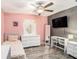 Inviting bedroom with wood-look floors featuring a white dresser and a sleek workstation setup at 146 Rain Berry Ave, Ruskin, FL 33570
