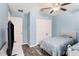 Light blue bedroom features wood-look floors, fan and comfortable bed with blue duvet at 146 Rain Berry Ave, Ruskin, FL 33570