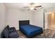 Cozy bedroom features modern dark wood flooring, a comfortable blue bed, and an adjacent lounge area at 146 Rain Berry Ave, Ruskin, FL 33570